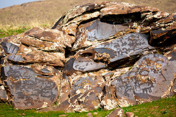 Petroglyphs on the rocks in Kazakhstan. The ancient parking cave man. Historical cave paintings. Carved on stone images of deer, goats and wolves. The development of ancient peoples.