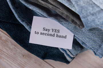 SAY YES TO SECOND HAND text on paper note on Jeans clothes assortment Second hand sustainable...