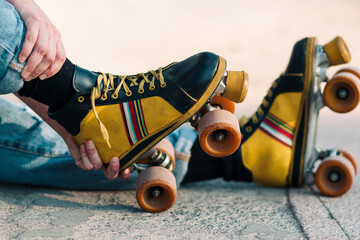 close up view of woman's hand arranging four-wheeled colored skates