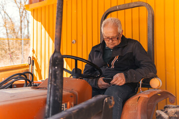 older man from modern countryside working with mobile