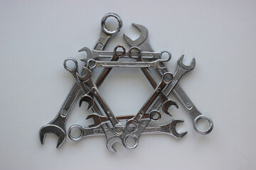 Geometrically laid out in a triangular shape, chrome plated wrenches of different sizes
