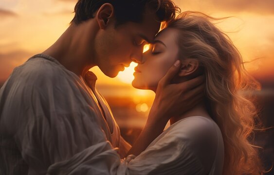 Romantic scene of young couple kissing against golden sunlight.