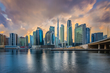 View of the Dubai skyline in the evening. Sunset over the skyscrapers with Burj Khalifa in the city's Marina Bay. Business center building and part of a bridge with streets