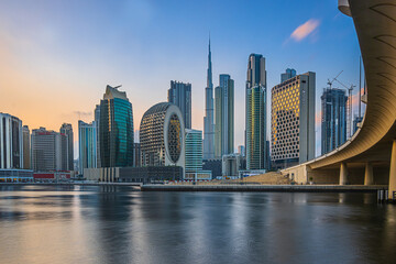 City view of the skyscrapers of Dubai City. Skyline of the Arabic city at sunset with the low sun. Business and financial buildings with Burj Khalifa in evening mood with bridge and road