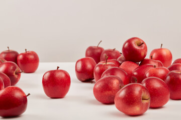 Front view of ripe red apples are decorated on a white background. Apples have many uses in beauty such as: whitening, exfoliating, tightening pores and anti-aging. Background for advertising