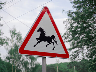 a road sign with the image of a horse. park. stalls. racetrack designation