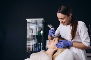 Woman getting a facial dermapen treatment at spa salon. Beauty concept. Face cosmetic procedure....