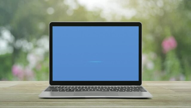 cctv camera flat icon with modern laptop computer on wooden table over blur pink flower and tree in park, Business security and safety online concept