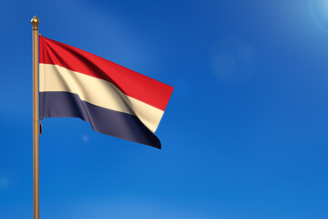 Netherlands. Flag blown by the wind with blue sky in the background.