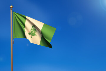 Norfolk Island. Flag blown by the wind with blue sky in the background.