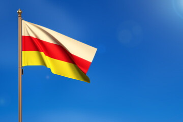 North Ossetia. Flag blown by the wind with blue sky in the background.