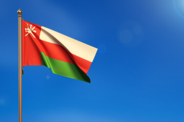 Oman. Flag blown by the wind with blue sky in the background.