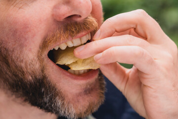 Kartoffelchips sind köstlich und werden in den Mund gesteckt