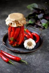 Tuinposter Homemade pickled chili peppers with garlic. © chudo2307