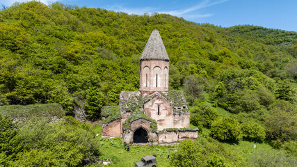 Obraz premium the ancient church hid in the forest in the gorge of the mountains of Armenia taken from a drone