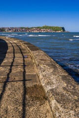 Path along the sea defences in Scarborough. This is a view of the headland and old town from near the star map in the South Bay.