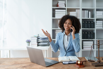 A young women African American lawyer lawsuit studying cases for clients with using smartphone...