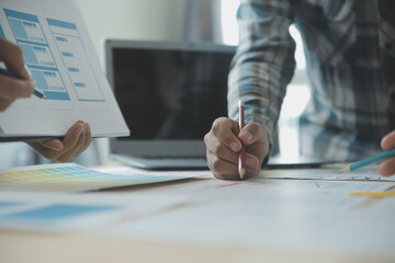 Close up ux developer and ui designer brainstorming about mobile app interface wireframe design on...