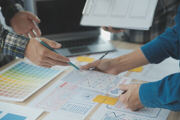 Close up ux developer and ui designer brainstorming about mobile app interface wireframe design on...