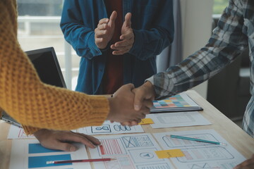 Close up ux developer and ui designer brainstorming about mobile app interface wireframe design on...