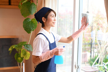 窓拭きをするハウスキーパーの女性