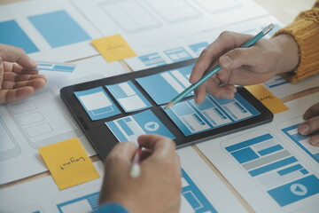 Close up ux developer and ui designer brainstorming about mobile app interface wireframe design on...