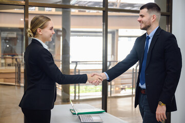 Businessman or manager handshake with young businesswoman business partners shaking hands in the office concept of partnership