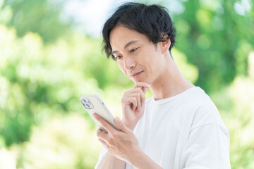 外でスマホを使うミドル男性