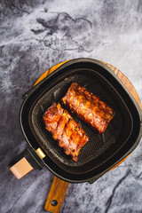 Modern cooking - preparing juicy spare ribs with honey sauce in airfryier, BBQ meat