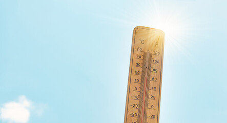 Thermometer with blue sky and sun, measure the temperature, weather forecast, global warming and environment discussion, summer season with heatwave

