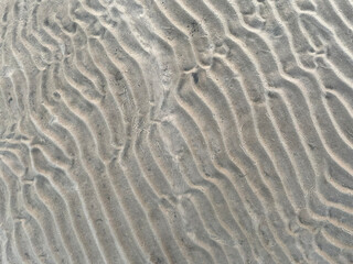 Fototapeta na wymiar top view of a waved sand texture on the summer beach