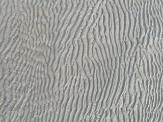Obraz premium top view of a waved sand texture on the summer beach