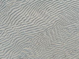top view of a waved sand texture on the summer beach