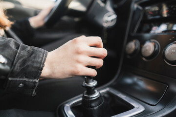person holding a manual shift knob in the vehicle