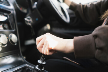 person holding a manual shift knob in the vehicle