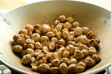 Kemiri or candlenut are fried in a frying pan before finally being mashed and the oil is squeezed out