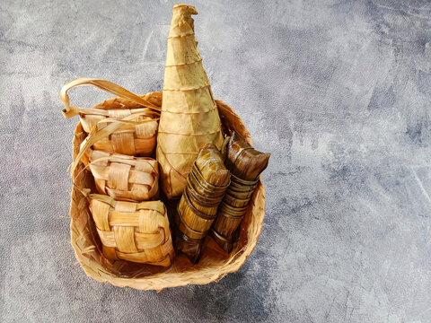 Ketupat or rice dumpling, lepat and lontong. Served in a bamboo basket. Indonesian food.