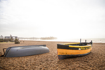 Small wooden rowing boats on the pebble beach of Brighton