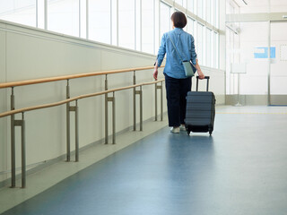 スーツケースを持って旅行に出発する女性のイメージ