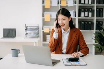 Happy asian business woman have the joy of talking on the smartphone, tablet and laptopon the  office .