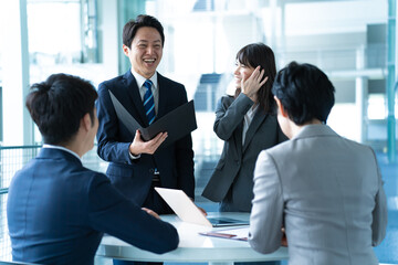 室内で会議をする４人のビジネスマン