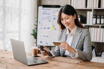 Woman using smart phone for mobile payments online shopping,omni channel,sitting on table,virtual icons graphics interface screen