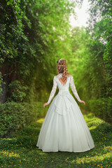 Obraz na płótnie Canvas Woman in wedding dress standing in front of sunny forest