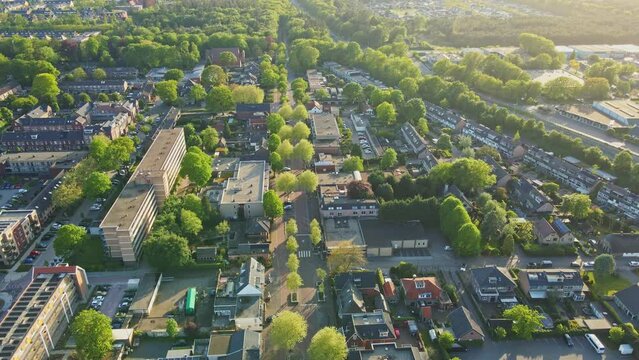 Aerial tilt up of beautiful small town surrounded by forest in summer at magic hour