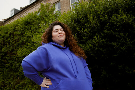 Confident curvy woman with vitiligo in workout clothes smiling at the camera