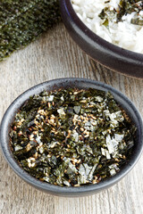 Vegan furikake seasoning with torn nori seaweed. Japanese cuisine condiment in a bowl.