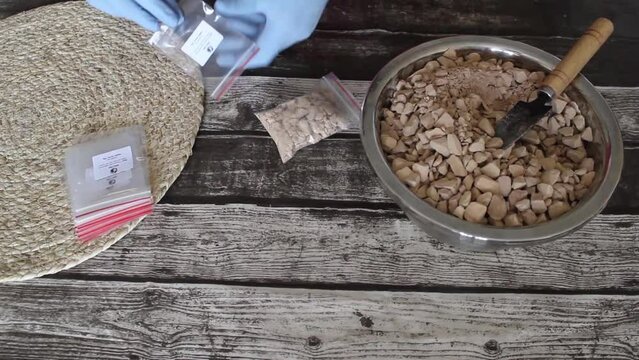Packing brown edible clay from a bowl.