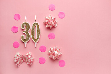 Number 30 on a pastel pink background with festive decor. Happy birthday candles. The concept of celebrating a birthday, anniversary, important date, holiday. Copy space. Banner