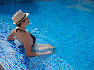 asian woman relaxing in swimming pool spa