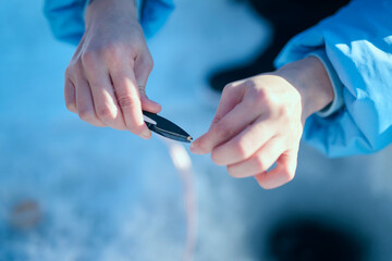 冬の湖でワカサギ釣りをする20代女性